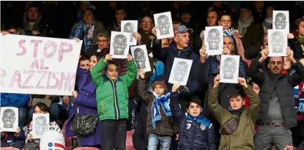 ??  ?? One voice: Fans holding up photos of Napoli defender Kalidou Koulibaly and an anti-racism banner that reads “Stop to racism” during the Serie A match between Napoli and Bologna at the San Paolo Stadium on Saturday. — AP