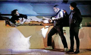  ?? [PHOTOS BY STEVE SISNEY, THE OKLAHOMAN] ?? Andru Dallaly, center, and Joe Hudson, right, interview Cotton Russell under an overpass before dawn Thursday during the city’s annual Point-in-Time homeless count.