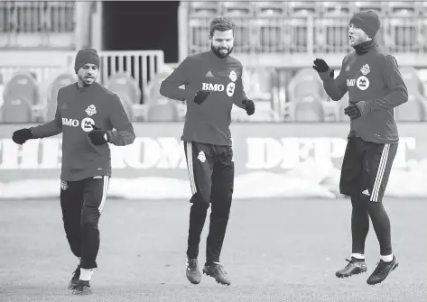  ?? PHOTOS: NATHAN DENETTE/THE CANADIAN PRESS ?? Toronto FC defender Jason Hernandez, left, defender Drew Moor, centre, and midfielder Michael Bradley get used to the cold at practice on Friday, one day before they host the MLS Cup final against the Seattle Sounders at BMO Field.