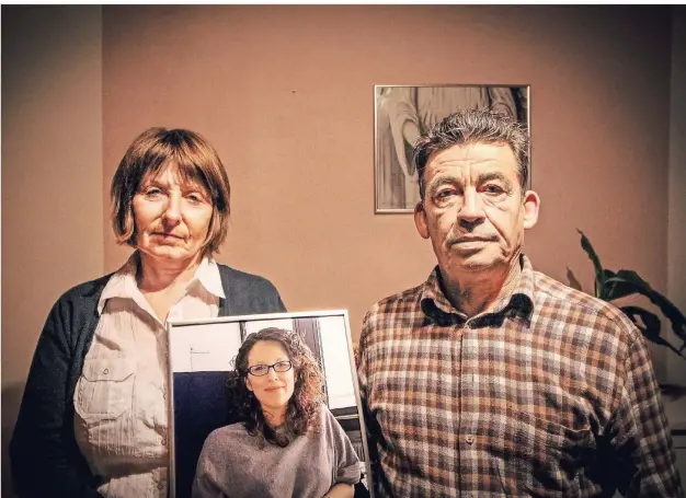  ?? FOTO: MARLEN KESS ?? Loréns Eltern, Charlotte Uceda Camacho und José Angel Uceda Camacho, in ihrem Wohnzimmer in Siegen. In den Händen halten sie ein Foto ihrer getöteten Tochter. Bis heute ist Lorén im Haus überall präsent, in der Küche steht ihr Sparschwei­n, an der Tür zum Arbeitszim­mer hängt ein von ihr gemaltes Bild.