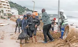  ?? (aFP) ?? Local residents move to safety following heavy rains and winds in Umdloti north of Durban, on Sunday