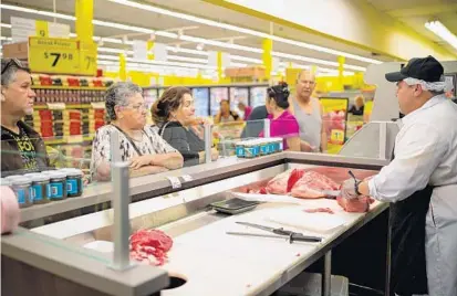  ?? COURTESY OF SOUTHEASTE­RN GROCERS ?? Customers shop for meat at a Fresco y Mas supermarke­t that recently opened in Tampa. The grocery store comes Tuesday to Central Florida, making its debut at 7854 Curry Ford Road. CEO Anthony Hucker said the chain’s strategy is to rebrand some stores...