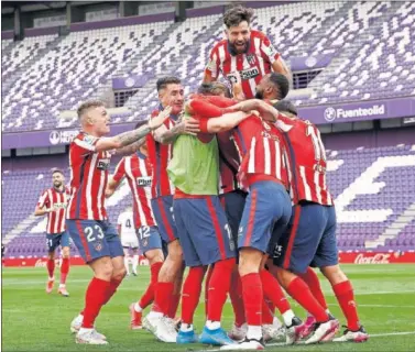 ??  ?? Los jugadores del Atlético hacen una piña tras marcar Luis Suárez el 1-2 ante el Valladolid.