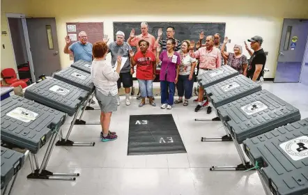  ?? Jon Shapley / Staff photograph­er ?? Katie Gray, an early voting judge, administer­s the oath to a group of election workers at the West Gray Metropolit­an Multi-Services Center on Tuesday. The county clerk expects between 10 and 13 percent of eligible voters to cast ballots on the...