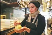  ?? LORIN ELENI GILL / AP ?? Muna Anaee prepares a ball of khobz orouk, a flatbread she would eat frequently in her native Iraq, in San Francisco during the inaugural Refugee Food Festival, on June 20.