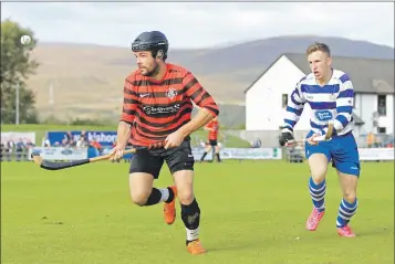  ?? Photo: Kim Ferguson ?? Oban Camanachd’s Daniel Cameron tries a wee bit keepie-uppie as he’s chased down by Andy MacKintosh.