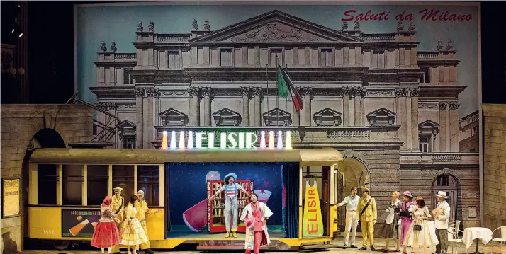  ??  ?? Stile cartolina Qui accanto, una scena dell’«Elisir d’amore» di Gaetano Donizetti. Sullo sfondo la facciata della Scala con il tram davanti