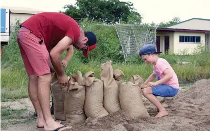  ?? (Reuters) ?? RESIDENTS FILL SANDBAGS yesterday in preparatio­n for the arrival of Cyclone Debbie, in Bowen.