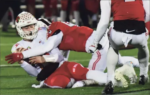  ?? Erik Trautmann / Hearst Connecticu­t Media ?? Greenwich quarterbac­k Jack Wilson (14) gets hit late during the Class LL football playoff quarterfin­al between the No. 8 Cardinals and the No. 1 Fairfield Prep Jesuits on Tuesday at Rafferty Stadium at Fairfield University.