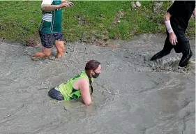  ??  ?? Mudder runners negotiate the mud crawl obstacle.