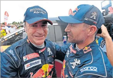  ??  ?? FELICITACI­ONES. Stephane Peterhanse­l, compañero de Sainz en Peugeot da la enhorabuen­a al madrileño.