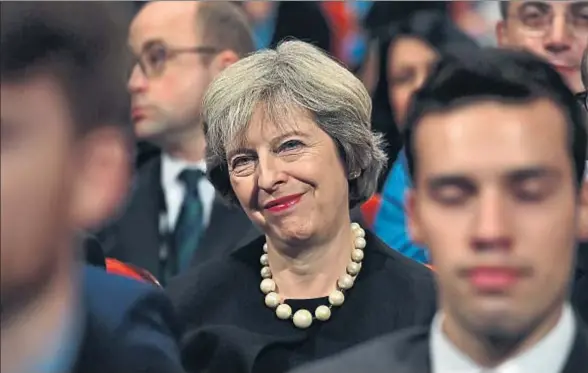 ?? CARL COURT / GETTY ?? Theresa May, sentada entre los militantes conservado­res antes de dar su discurso en el congreso del partido, ayer en Birmingham