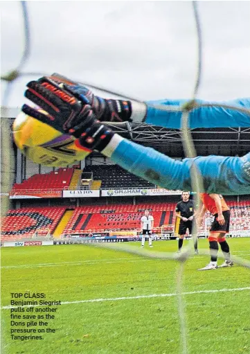  ??  ?? TOP CLASS: Benjamin Siegrist pulls off another fine save as the Dons pile the pressure on the Tangerines.