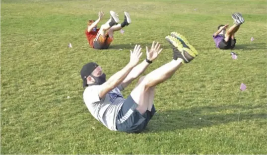  ??  ?? East Mountain’s new coach Sam Slaven and his cross country team during a core-conditioni­ng workout.