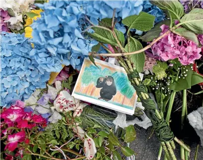  ?? IAIN McGREGOR/STUFF ?? Tributes outside the Dunedin house where Edward Livingston­e killed his two children before turning the gun on himself.