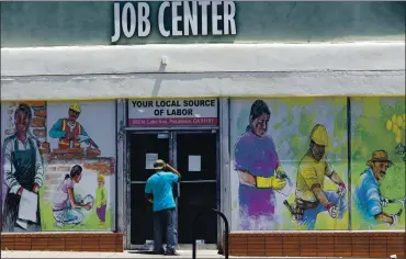  ?? DAMIAN DOVARGANES — THE ASSOCIATED PRESS ?? A person looks inside the closed doors of the Pasadena Community Job Center in Pasadena in May during the coronaviru­s outbreak. The U.S. still has 8.4 million fewer jobs than it had in February 2020, before the pandemic struck.