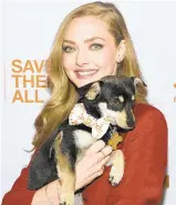  ?? EVAN AGOSTINI/AP ?? Actress Amanda Seyfried poses with a puppy at the fourth annual Best Friends Animal Society benefit gala at Guastavino’s in New York in April.