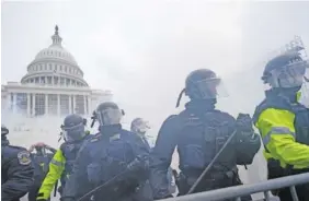  ?? AP PHOTO/JULIO CORTEZ ?? Police stand guard after holding off rioters who tried to break through a police barrier at the Capitol in Washington on Jan. 6.