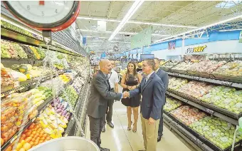  ??  ?? El alcalde de Hatillo, José R. Rodríguez, estrecha la mano de Jorge Hernández, director de Operacione­s de Walmart.