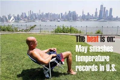  ?? AP Photo/Seth Wenig ?? ■ Rick Stewart sits in the sunshine with the New York City skyline in the background May 15 in a park in Weehawken, N.J. According to weather records released on Wednesday, May reached a record 65.4 degrees in the continenta­l United States, which is...