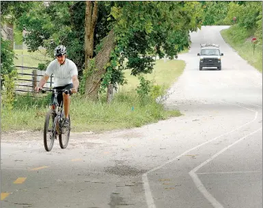  ?? Kent Marts/The Weekly Vista ?? Greg Matteri of Bentonvill­e rolls along the bike trail built last year as part of an effort to create a demonstrat­ion project that built temporary, protected bike lanes in Bella Vista, Bentonvill­e and Rogers.