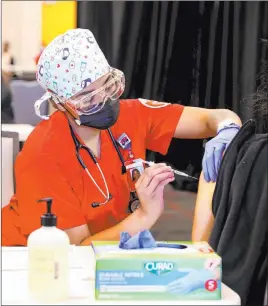  ?? K.M. Cannon Las Vegas Review-journal @Kmcannonph­oto ?? Nursing student Alaysia Robinson administer­s a COVID-19 vaccine shot during a UNLV Medicine clinic Friday in the university’s student union.