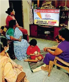  ??  ?? In casa
Una famiglia ascolta le notizie nel salotto di casa a Bangalore, in India