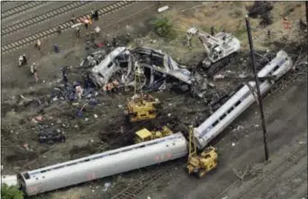 ?? PATRICK SEMANSKY - THE ASSOCIATED PRESS ?? In this May 13, 2015, file photo, emergency personnel work near the wreckage of a New York City-bound Amtrak passenger train following a derailment that killed eight people and injured about 200 others in Philadelph­ia. The state’s attorney general has...