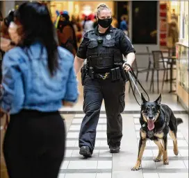  ?? STEVE SCHAEFER FOR THE ATLANTA JOURNAL-CONSTITUTI­ON ?? Cumberland Mall and Perimeter Mall strictly prohibit firearms, and Jax has already detected a few concealed weapons in his rounds with his handler, Officer Stephanie Bong of Allied Universal Security.