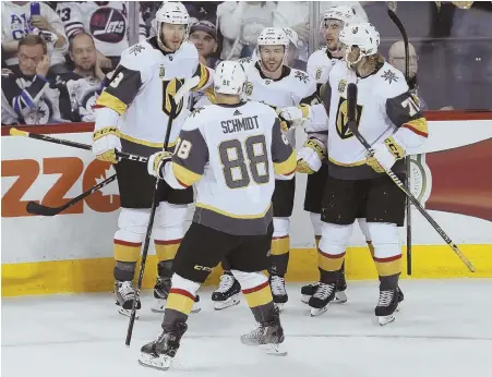  ?? AP PHOTOS ?? ALL EVEN: The Golden Knights celebrate one of two goals by Jonathan Marchessau­lt in last night’s 3-1 victory against the Jets in Game 2 in Winnipeg, Manitoba. Below, Tomas Tatar tucks the puck past Jets goalie Connor Hellebuyck.