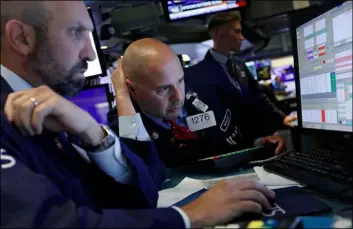  ?? AP PHOTO/RICHARD DREW ?? In this Oct. 2 file photo specialist­s James denaro (left) and Mario Picone work on the floor of the new york Stock Exchange.