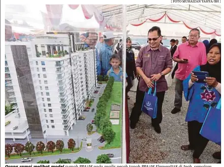  ?? [ FOTO MUHAIZAN YAHYA/BH ] ?? Orang ramai melihat model rumah PPA1M pada majlis pecah tanah PPA1M Elemen@18 di Ipoh, semalam.