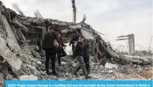  ?? ?? GAZA: People inspect damage to a building that was hit overnight during Zionist bombardmen­t in Rafah in the southern Gaza Strip on March 26, 2024.— AFP