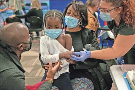  ?? MADDIE SCHROEDER/THE COLUMBUS DISPATCH ?? Amaya Marshall is comforted by her parents, Randy and Nooriyal, as Central Ohio Primary Care employee Heather Hendrickso­n prepares to inoculate Amaya on Saturday in Westervill­e.