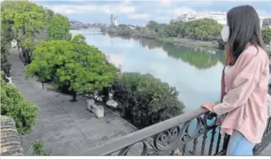  ??  ?? Una joven mira el Paseo de la O desde el Puente de Triana.