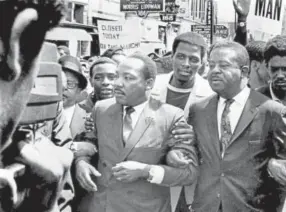  ?? Sam Melhorn, The Commercial Appeal via AP ?? The Rev. Martin Luther King Jr. and Rev. Ralph Abernathy, right, lead a march on behalf of striking sanitation workers in Memphis, Tenn., on March 28, 1968. King was assassinat­ed a week later in Memphis.