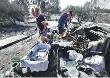  ?? AFP ?? Katherine Marinara and her son Luca return to the charred remains of their home in Malibu, California on Tuesday