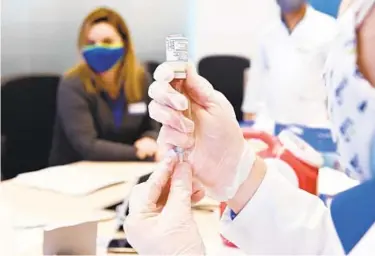  ?? KENNETH K. LAM/BALTIMORE SUN ?? A Rite Aid health care worker prepares a dose of COVID-19 vaccine at the Emergent BioSolutio­ns facility on Feb. 8, where the vaccine is being manufactur­ed in Baltimore.