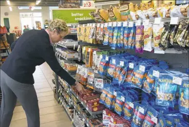  ?? Darrell Sapp/Post-Gazette photos ?? Polly Flinn, senior vice president and general manager for GetGo, shows selection of snacks in Verona.