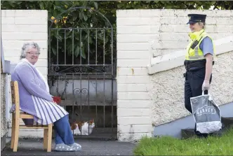  ?? Photo by Domnick Walsh ?? Garda Mary Gardiner on her way with shopping bags to help locals who can’t make it to the shops. Here Mary stops to talk to Phyllis McLaughlin from Tralee.