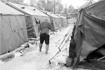  ??  ?? File photo shows a man walking between tents at Australia’s regional processing centre on Manus Island in Papua New Guinea. — AFP photo