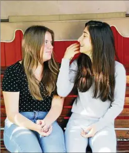  ??  ?? Abir (rechts) mit ihrer Freundin Marie-Sophie auf der Hollywood-Schaukel im Garten des Franziskus­hauses der Stiftung Finneck in Rastenberg. Foto: Armin Burghardt