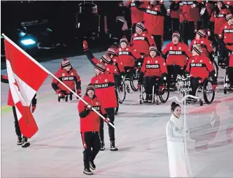  ?? NG HAN GUAN
THE ASSOCIATED PRESS ?? Brian McKeever carries the flag of Canada as he leads his teammates into the opening ceremony of the 2018 Winter Paralympic­s in Pyeongchan­g on Friday.