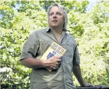  ?? JESSICA NYZNIK/EXAMINER ?? Author Drew Hayden Taylor holds a copy of his latest book, Take Us to Your Chief, at his home in Curve Lake on Monday. The science-fiction book of short stories has a First Nations outlook.