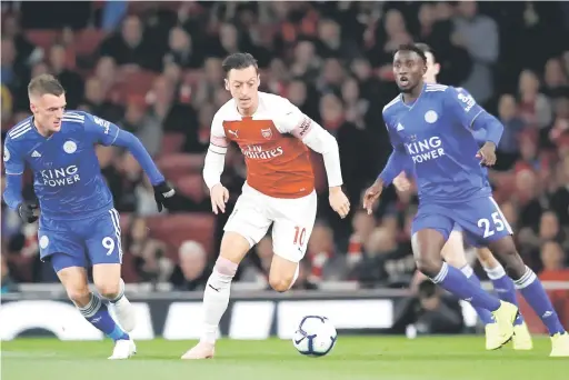  ??  ?? TARIK PERHATIAN: Ozil (tengah) lakukan gerakan menarik ketika bersaing dengan Vardy pada perlawanan liga di Stadium Emirates, London lepas.