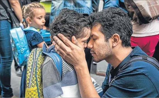  ?? LUIS TATO ?? Padres e hijos se despidiero­n ayer a las puertas de la escuela, como estos del colegio Jaume I de Barcelona