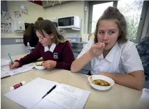  ?? MURRAY WILSON/STUFF ?? Waiopehu College year 9 students Sophie Bell and Maddi Stevens eat butter chicken and rice while doing their schoolwork.