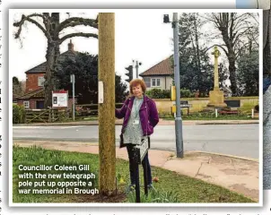  ?? ?? Councillor Coleen Gill with the new telegraph pole put up opposite a war memorial in Brough