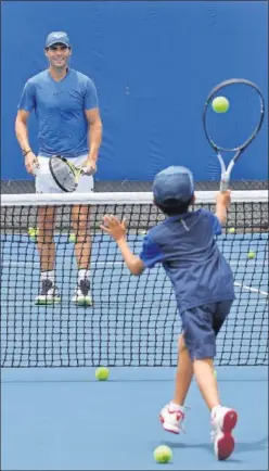  ??  ?? ACTIVO. Rafa Nadal pelotea con un niño en Brisbane.