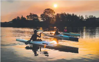  ?? Picture: GLENN HAMPSON ?? Currumbin Paddlers Club host a “come and try day” for young kayakers at Lake Orr, Varsity Lakes, in front of an eerie smoke haze from the Hinterland burn-offs.